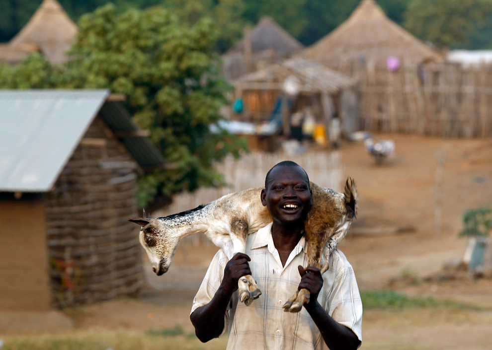 Man carries a goat in south sudan